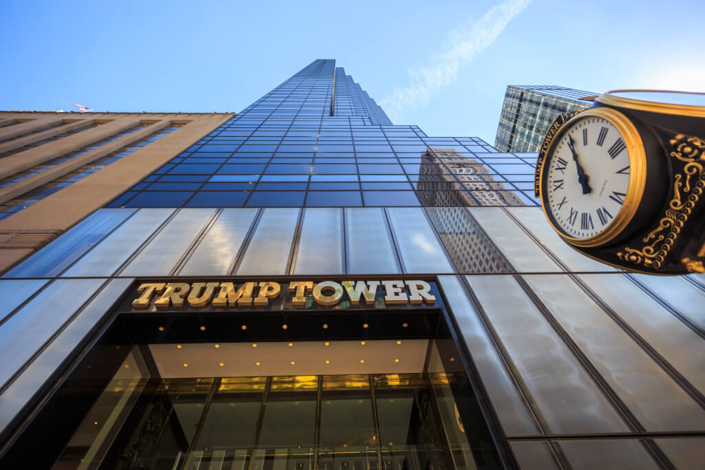 Looking up at the 5th avenue Trump Tower with the gold name and clock in sight