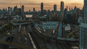 Subway of Long Island City with the view of building construction in Greenpoint, Brooklyn and luxury condos of Hunters Point. Distant view of Manhattan over the East River.