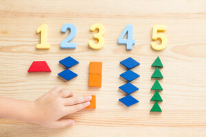 The child is studying the numbers and the account. Arranges the colored blocks to the desired numbers. Mathematics for children.