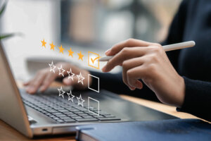 Businessman typing on a computer keyboard, customer service satisfaction survey concept. Business people choose the highest satisfaction rating and give 5 stars. Satisfaction, rating, rating.