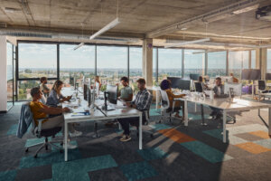 Large group of programmers working in a modern office of a software company. Copy space.
