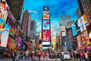 Times Square with tourists. Iconified as "The Crossroads of the World" it's the brightly illuminated hub of the Broadway Theater District.