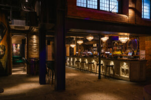 A wide angle view of an empty nightclub in Newcastle upon Tyne in the North East of England. The club has an urban loft style theme with lots of exposed steel beams and open plan dance floor area