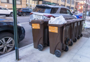 Christopher street, Greenwich Village, Manhattan, New York, USA - March, 2024. Recycling/garbage bins beside the road waiting for collection.
